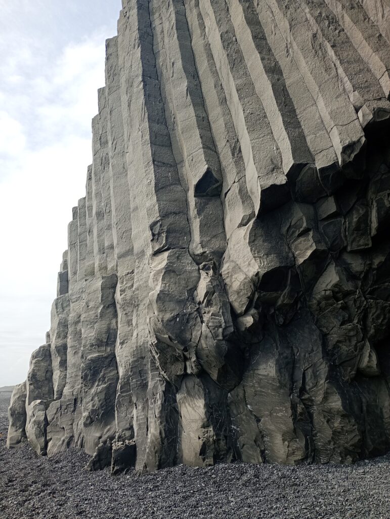 Kolumny bazaltowe na czarnej plaży Reynisfjara sprzed jej erozji