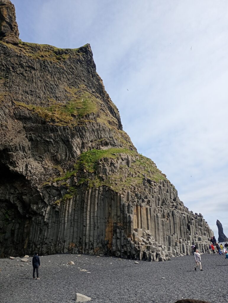 Kolumny bazaltowe na czarnej plaży Reynisfjara sprzed jej erozji